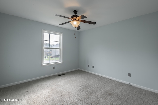 carpeted spare room featuring ceiling fan