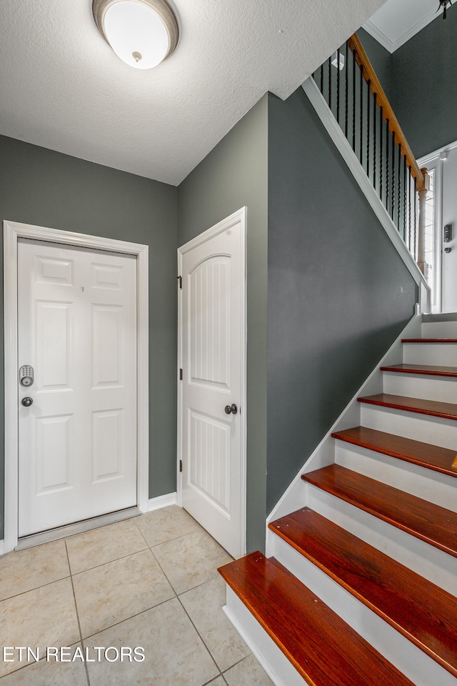 foyer featuring a textured ceiling and light tile patterned floors