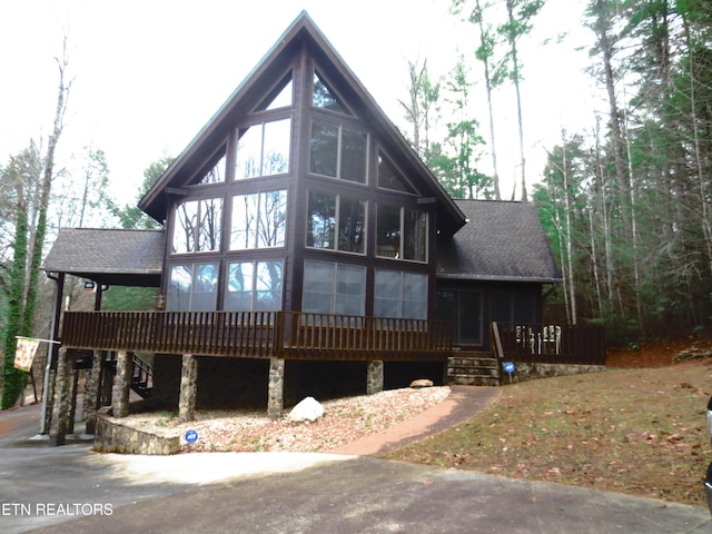 exterior space with a wooden deck and a sunroom