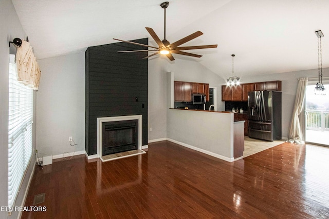 unfurnished living room featuring a fireplace, ceiling fan with notable chandelier, light hardwood / wood-style flooring, and vaulted ceiling