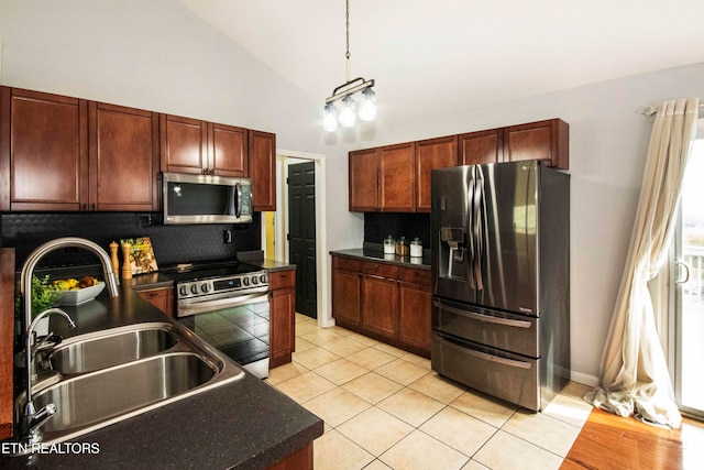 kitchen featuring appliances with stainless steel finishes, backsplash, sink, light tile patterned floors, and decorative light fixtures