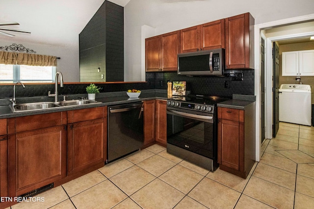 kitchen featuring sink, decorative backsplash, light tile patterned floors, washer / dryer, and stainless steel appliances