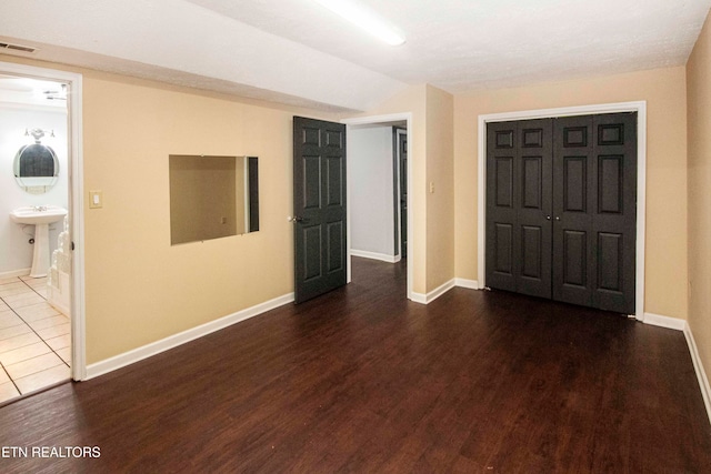 interior space featuring dark hardwood / wood-style floors, sink, ensuite bathroom, and a closet