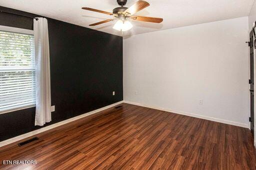 empty room featuring ceiling fan and dark wood-type flooring