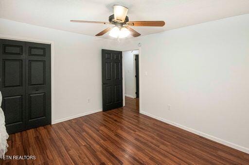 unfurnished bedroom with a closet, ceiling fan, and dark wood-type flooring