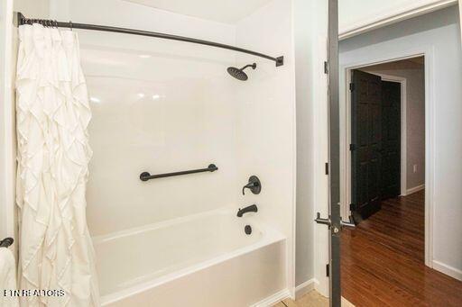 bathroom featuring shower / bath combo and wood-type flooring