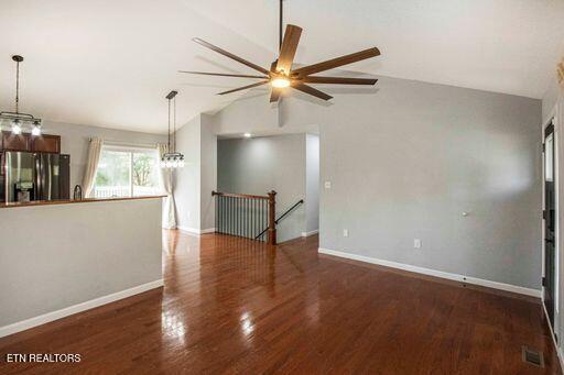 unfurnished room featuring ceiling fan, dark wood-type flooring, and lofted ceiling