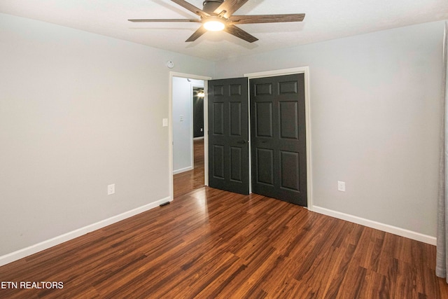 unfurnished bedroom with dark hardwood / wood-style floors and ceiling fan