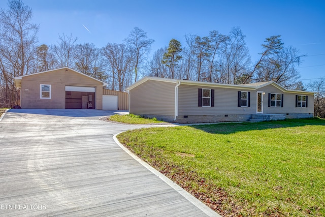 single story home featuring an outbuilding, a garage, and a front lawn