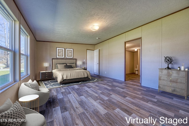 bedroom with wood-type flooring, a textured ceiling, and multiple windows