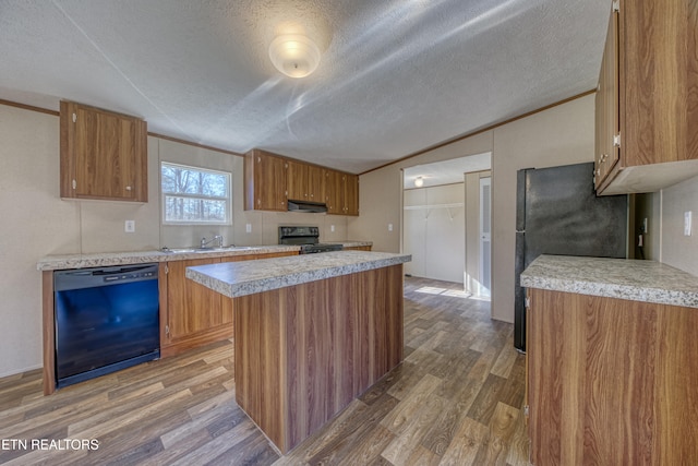 kitchen featuring ventilation hood, a textured ceiling, hardwood / wood-style flooring, and black appliances