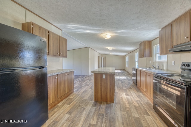 kitchen with a kitchen island, black appliances, a textured ceiling, and light hardwood / wood-style floors