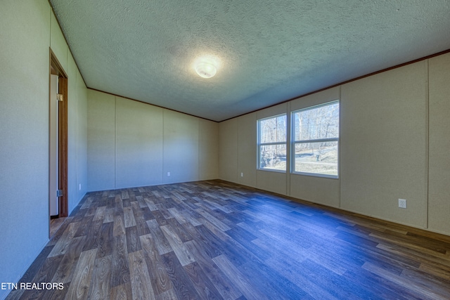 spare room with dark wood-type flooring and a textured ceiling