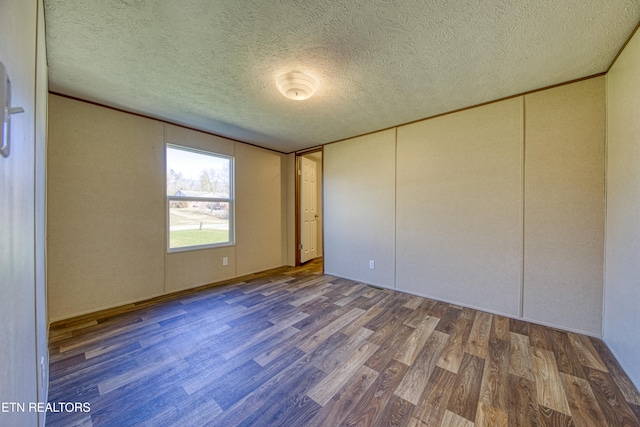 unfurnished bedroom featuring dark hardwood / wood-style flooring and a textured ceiling