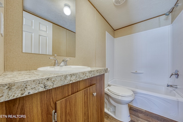 full bathroom with washtub / shower combination, a textured ceiling, toilet, vanity, and hardwood / wood-style flooring