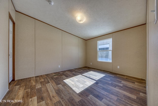 unfurnished bedroom featuring a textured ceiling, dark hardwood / wood-style flooring, and ornamental molding