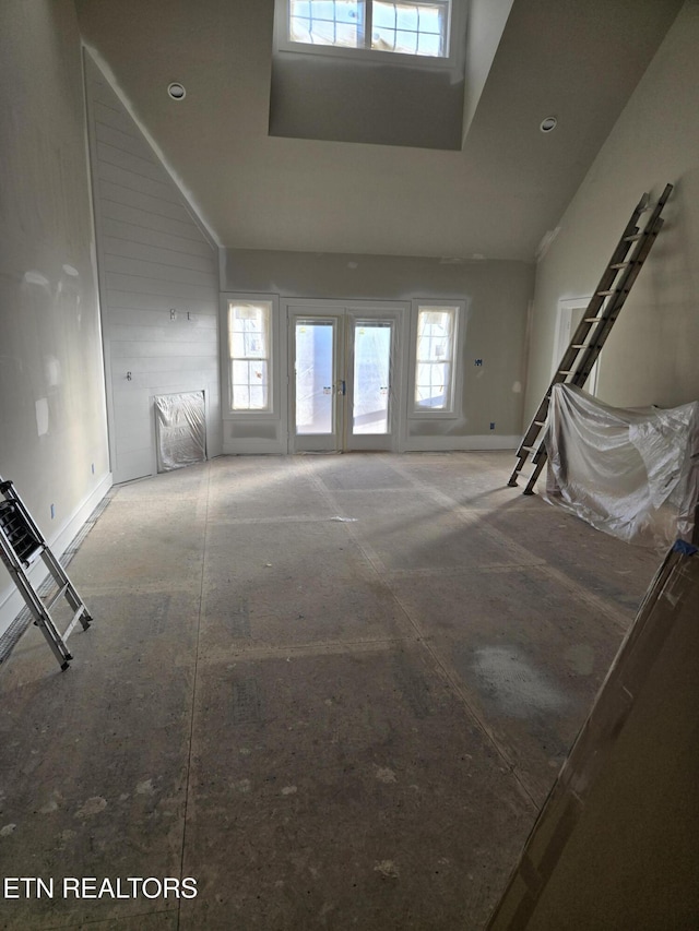 unfurnished living room with a towering ceiling