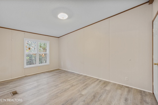 spare room with crown molding and light hardwood / wood-style flooring