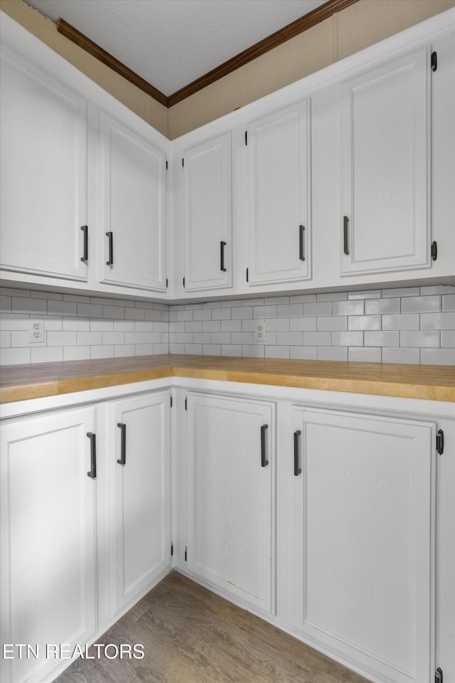 clothes washing area featuring light hardwood / wood-style flooring and ornamental molding