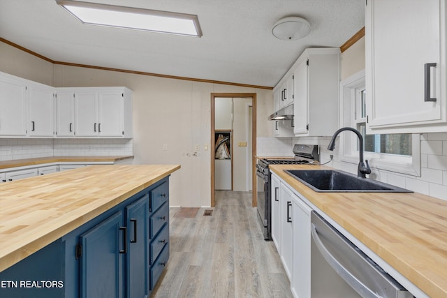 kitchen with white cabinetry, sink, appliances with stainless steel finishes, and vaulted ceiling