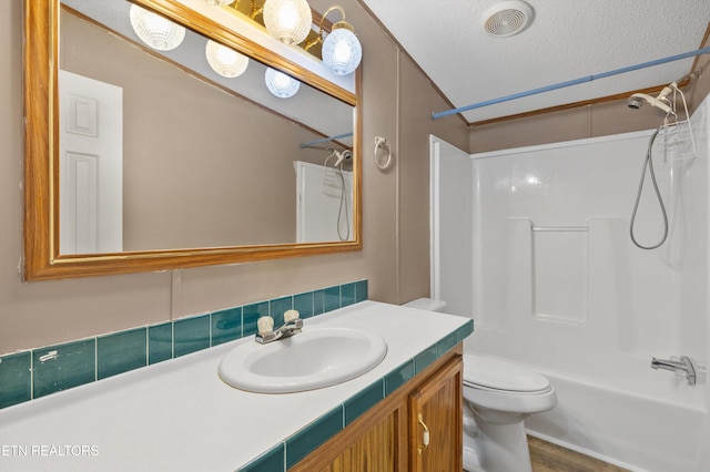 full bathroom with vanity, a textured ceiling, shower / washtub combination, hardwood / wood-style flooring, and toilet