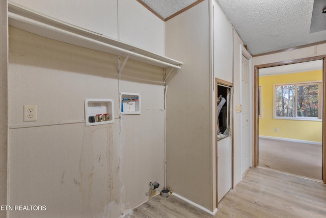 laundry room with light hardwood / wood-style floors and a textured ceiling