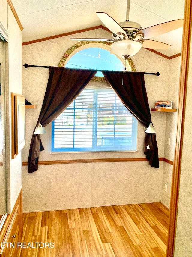 unfurnished bedroom featuring ceiling fan, light hardwood / wood-style floors, vaulted ceiling, and ornamental molding