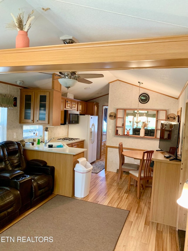 kitchen with kitchen peninsula, pendant lighting, light hardwood / wood-style floors, and lofted ceiling