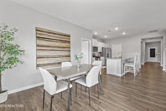 dining area featuring dark wood-type flooring and sink