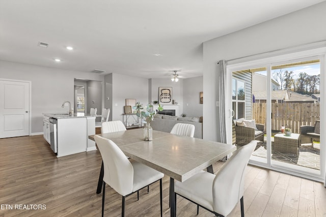 dining area with dark hardwood / wood-style floors, ceiling fan, and sink