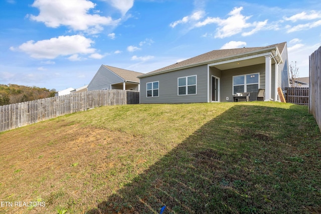 rear view of house featuring a yard