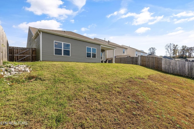 back of house featuring a lawn