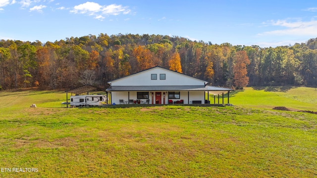 farmhouse inspired home with an outbuilding, a carport, and a front lawn