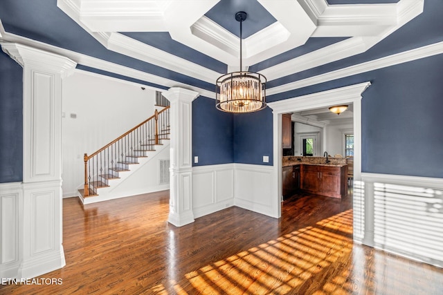 unfurnished dining area featuring ornate columns, sink, dark wood-type flooring, a tray ceiling, and ornamental molding