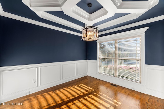 spare room featuring a chandelier, hardwood / wood-style floors, and ornamental molding