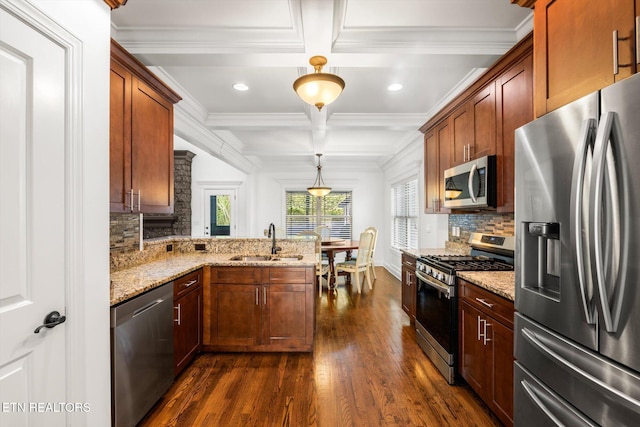 kitchen featuring sink, dark wood-type flooring, hanging light fixtures, stainless steel appliances, and decorative backsplash