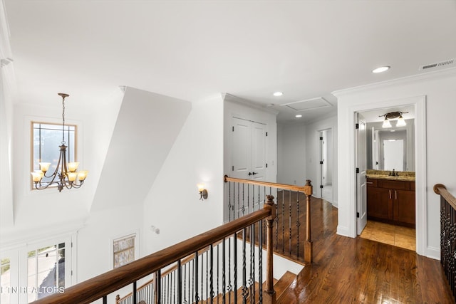 hallway with a notable chandelier, a healthy amount of sunlight, dark hardwood / wood-style flooring, and sink