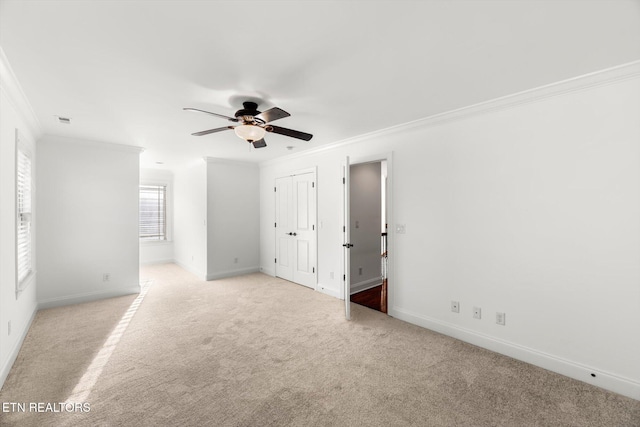 spare room with light carpet, ceiling fan, and ornamental molding