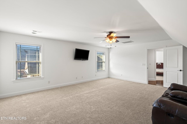 unfurnished living room with ceiling fan, carpet floors, and vaulted ceiling