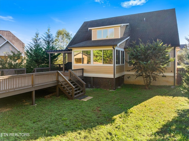 back of property with a sunroom, a deck, and a yard