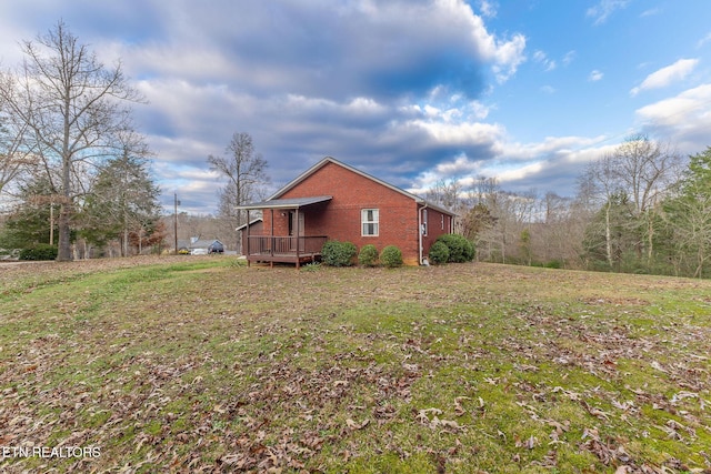 view of side of property with a wooden deck and a lawn