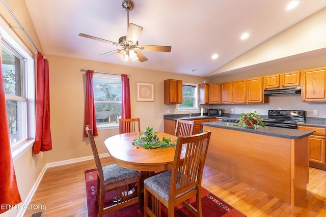 kitchen featuring lofted ceiling, ceiling fan, electric range, light hardwood / wood-style floors, and a kitchen island