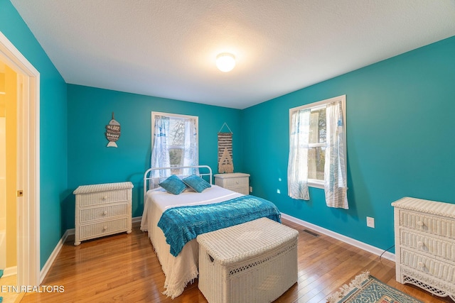 bedroom featuring wood-type flooring and multiple windows