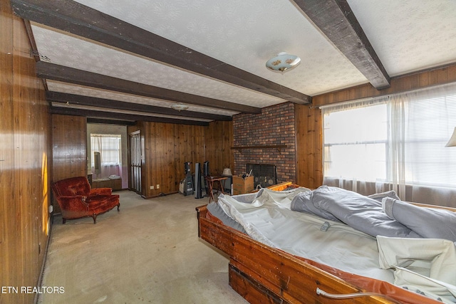 carpeted bedroom featuring beam ceiling, a textured ceiling, a brick fireplace, and wooden walls