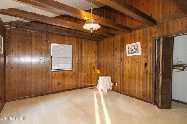 carpeted empty room with wooden walls and beamed ceiling