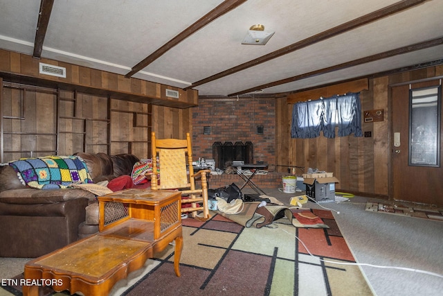 living room with carpet flooring, wood walls, and beamed ceiling