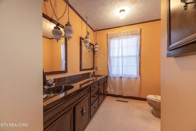 bathroom featuring crown molding, vanity, a textured ceiling, and toilet