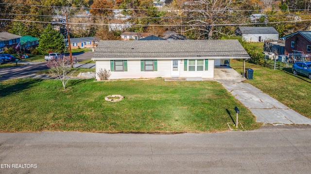 view of front of property featuring a front yard, a carport, and an outdoor fire pit