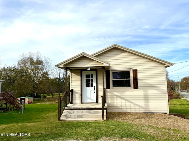 bungalow-style home with a front yard