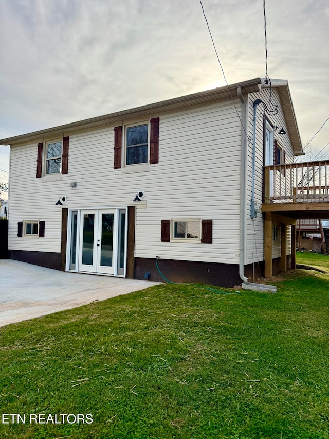 rear view of house with french doors, a yard, a patio area, and a wooden deck